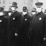 old black and white image from the 1900's with Police officers wearing masks