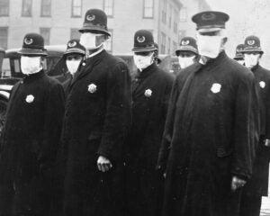 old black and white image from the 1900's with Police officers wearing masks